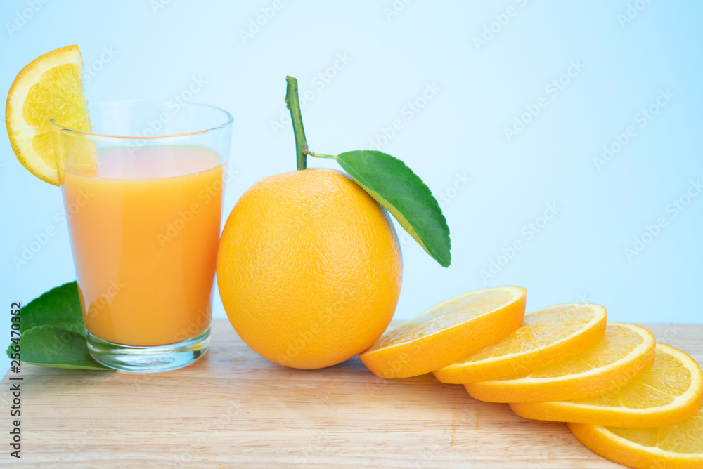 Naklejka premium Orange juice and oranges with leaves