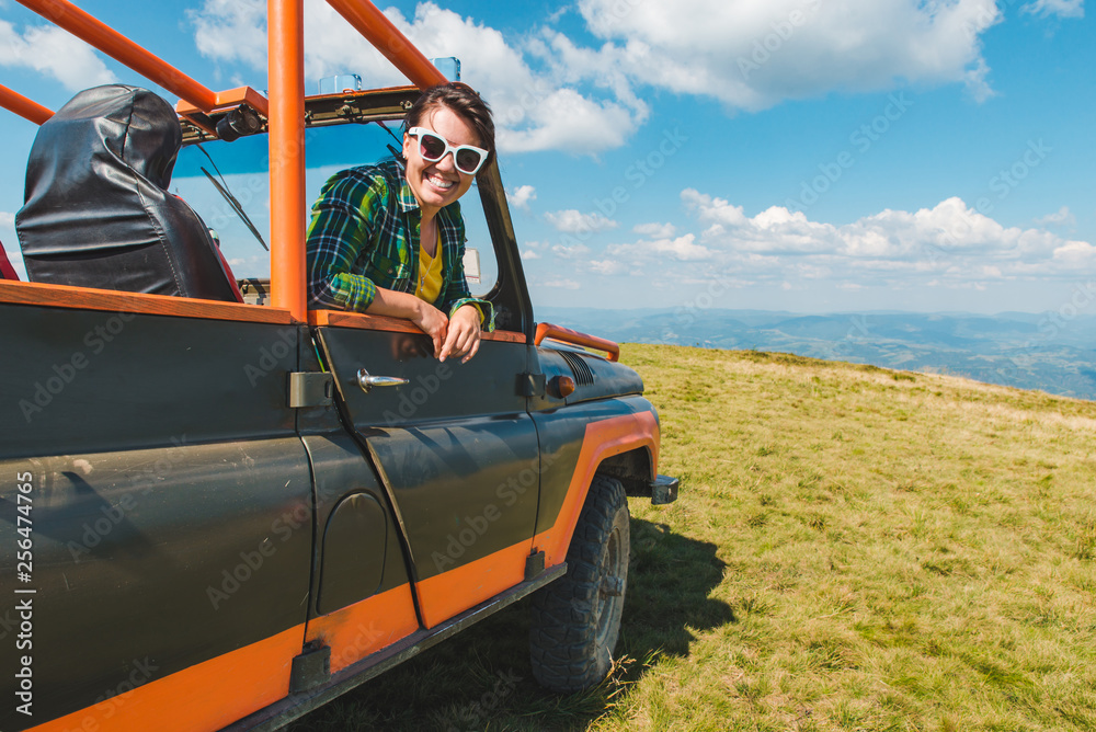 Obraz premium woman in off road cur at the top of the mountain. beautiful view on background. copy space