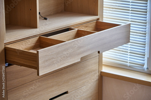 Wooden cupboard with opened drawer. Modern furniture