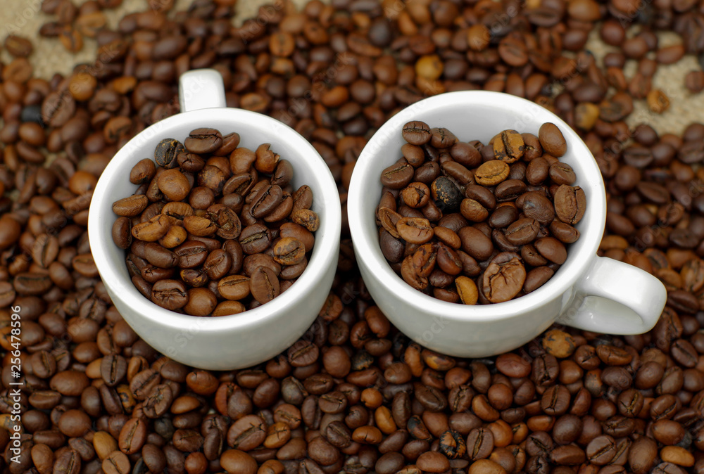 Cup of coffee full of coffee beans. Сoffee cup and coffee beans. Cup full of coffee beans on the cloth sack Cup of coffee full of coffee beans. Сoffee cup and coffee beans. Cup full of coffee beans on the cloth sack