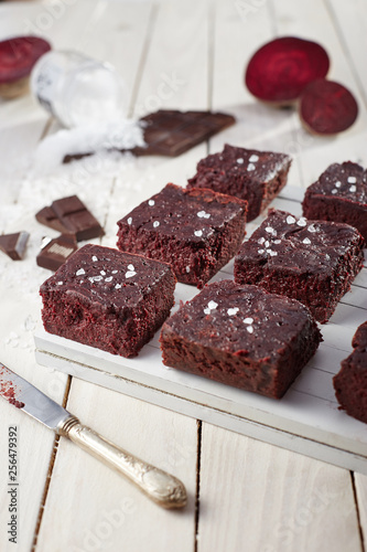 Beetroot brownie on a white wooden background from a side