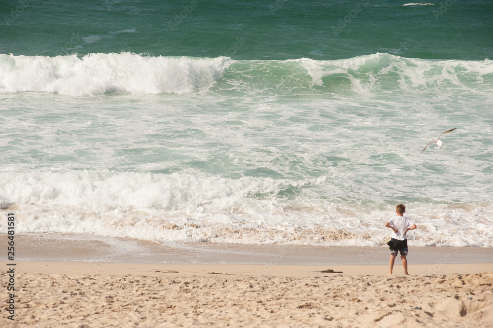 Boy on beach near waves