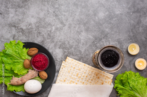 Jewish holiday Passover background with wine, matza and seder plate on grey. Top view. With copy space photo