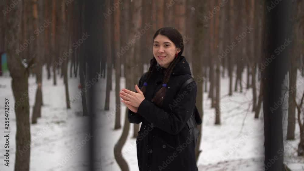 Girl Eastern looks walking in the forest in the winter. Cheerful and beautiful woman posing in the Park. Concept: a walk in the fresh air, the guarantee of health and good mood Girl Eastern looks walking in the forest in the winter. Cheerful and beautiful woman posing in the Park. Concept: a walk in the fresh air, the guarantee of health and good mood