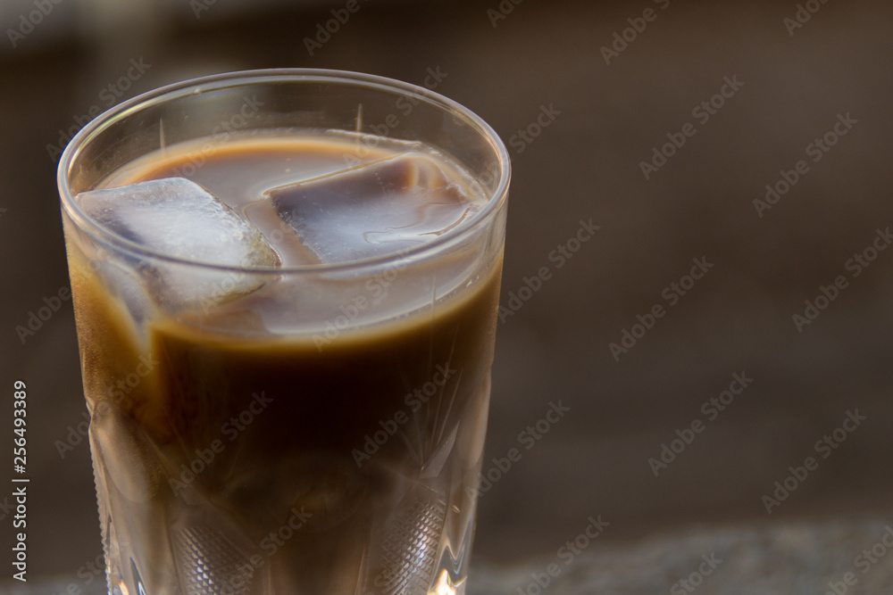 Tasty fresh cold iced coffee with milk in glass on table