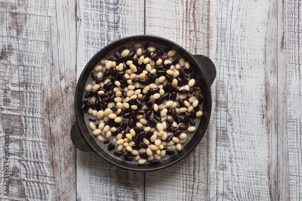 Stewed beans in a pan on a wooden table. Stewed beans in a pan on a wooden table.
