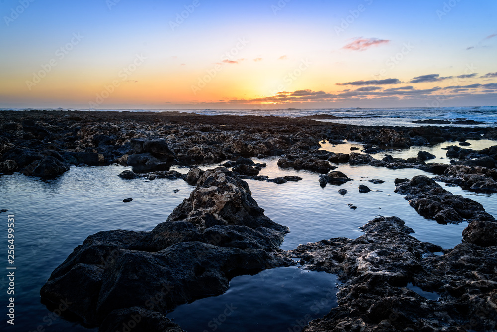 Scenic view of rocky beach at sunset Scenic view of rocky beach at sunset