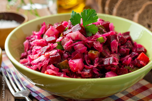 Canvas Print Traditional russian salad vinaigrette with boiled vegetables, pickled cucumbers and sauerkraut in bowl on wooden table