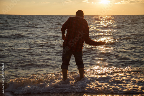 A man throws stones on the Black Sea, Sochi.