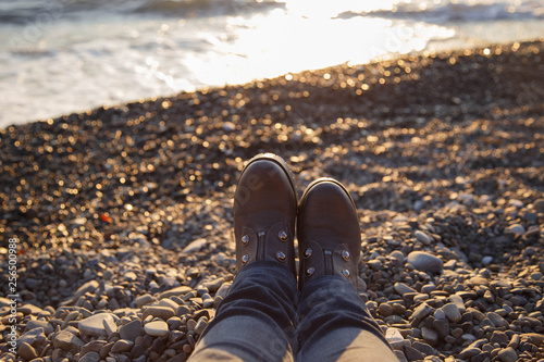 Feet in boots close-up on the Black Sea, Sochi.