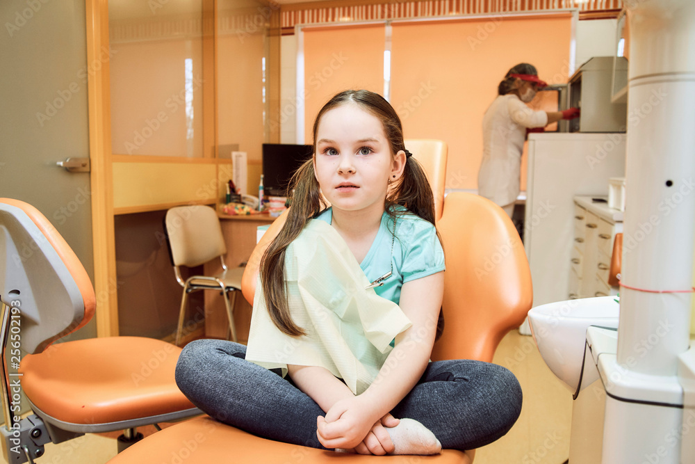 Pediatric dentistry. Girl sitting on a dental chair Pediatric dentistry. Girl sitting on a dental chair