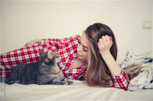 Beautiful woman hugging and playing with cat