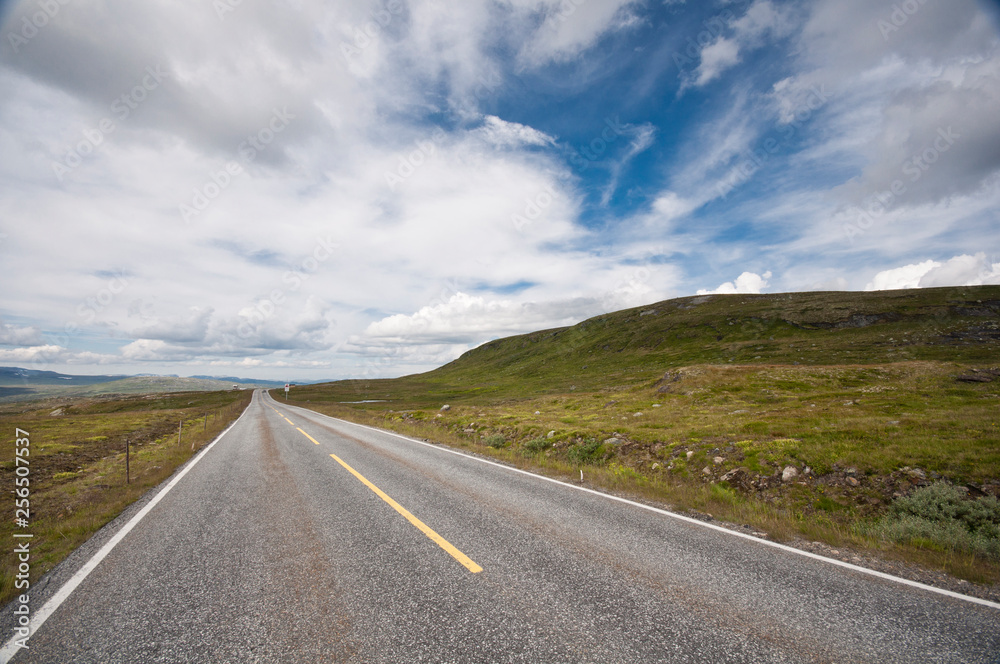 Empty road through beautiful landscape with blue sky Empty road through beautiful landscape with blue sky