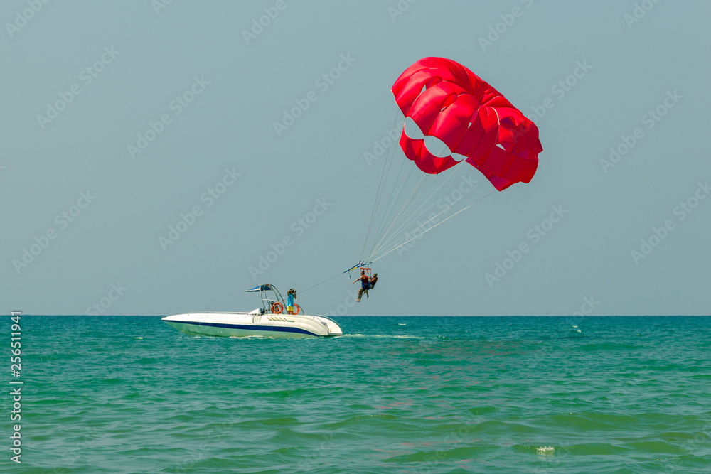 Tourists have fun, parachuting behind a boat, parasailing Stock Photo