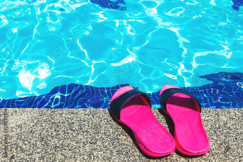 Summer background with slippers for the pool fuchsia colors near the pool