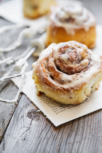 Cinabon rolls with cream cheese and cream, chocolate and almond nuts on wooden background photo