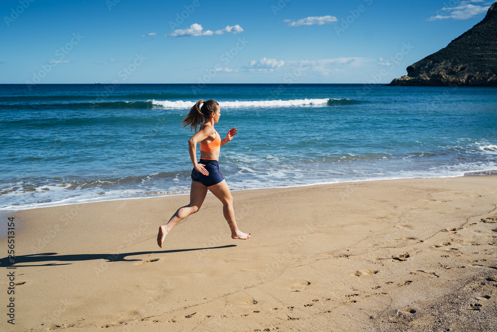Fitness young woman running on the beach during summer holiday Fitness young woman running on the beach during summer holiday