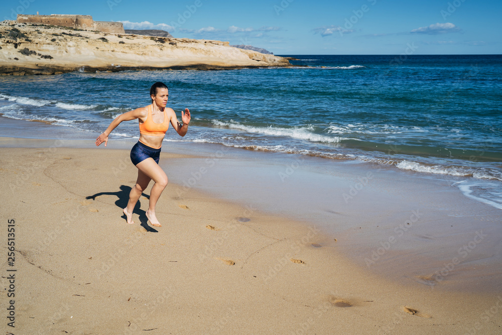 Fitness young woman running on the beach during summer holiday Fitness young woman running on the beach during summer holiday