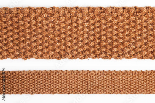 Brown linen textile strap isolated on white. Fiber fabric retro belt texture. photo