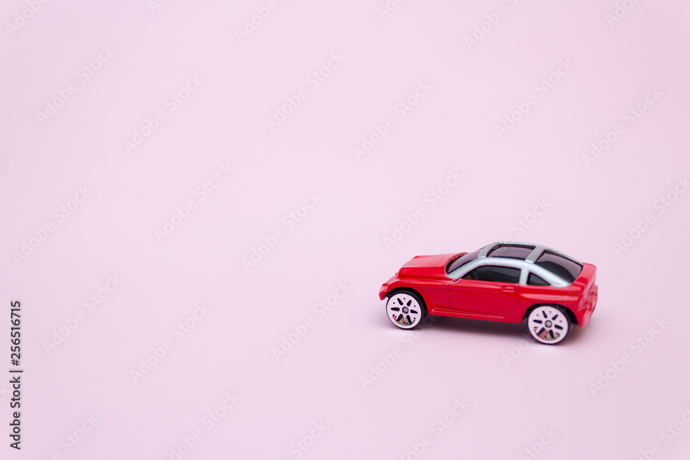 Toy red car on a pink background, gentle concept.