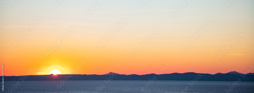 Sunset over Attica, clear blue orange color sky background, Kea island, Greece.
