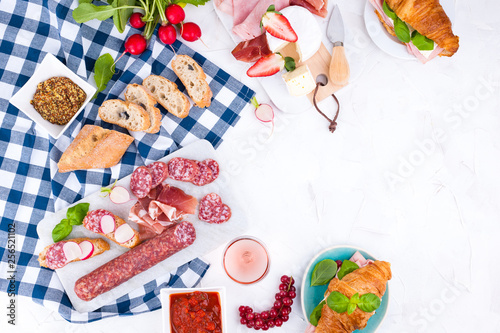 Appetizers table with italian antipasti snacks and wine in glasses. Salami and bruschetta with fresh vegetables on a white background. Free space for text. Traditional snacks for wine.