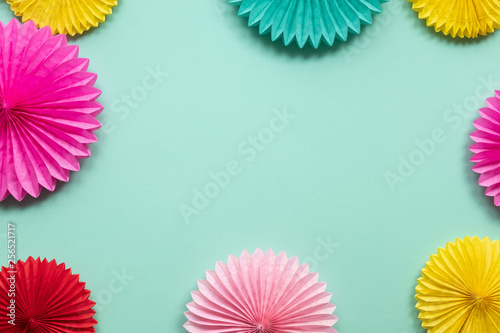 Diffrent paper flowers on green table top view. Festive or party background.  Copy space for text. Birthday greeting card.