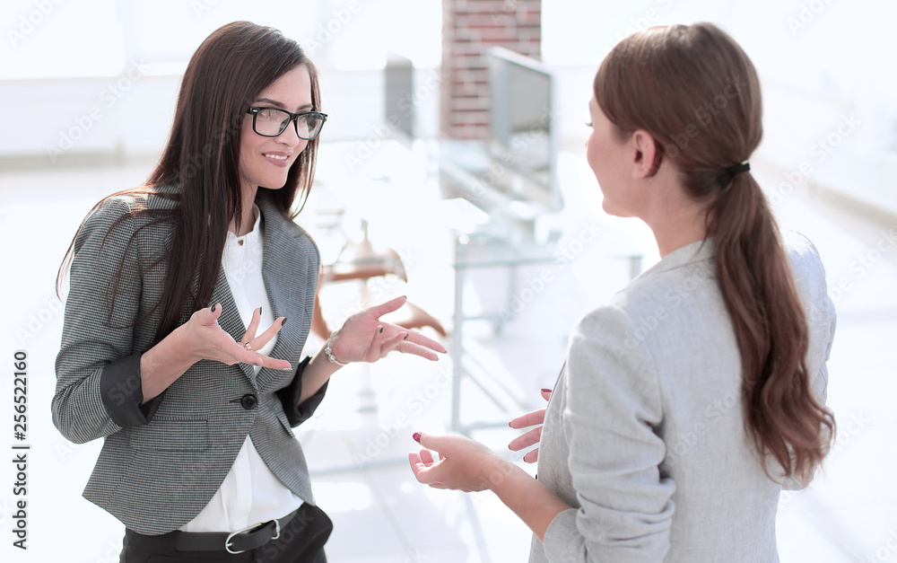 two employees talking standing in the office two employees talking standing in the office