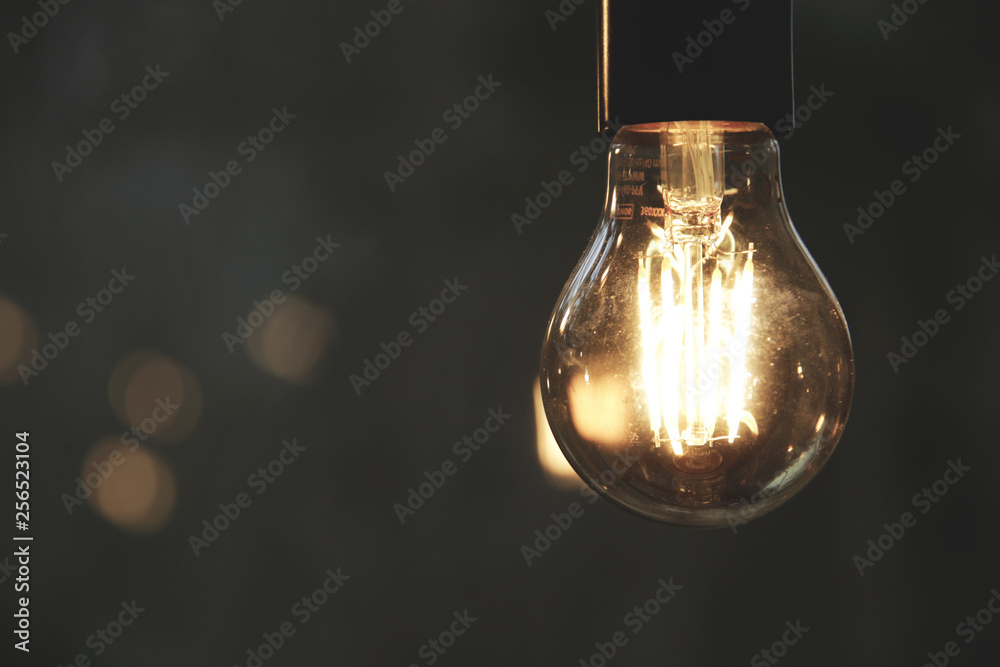 Modern light bulb in dark with free space Modern light bulb in dark with free space