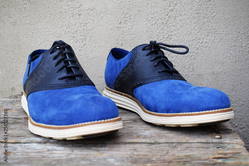 Dark blue sneakers with a white sole on a wooden background