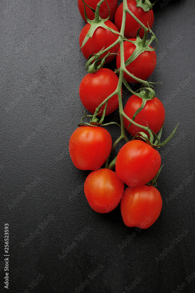 Red cherry tomatoes on black background Red cherry tomatoes on black background