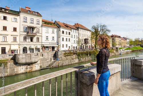 Young woman is admiring old buildings and apartments in old part of Ljubljana, Slovenia
