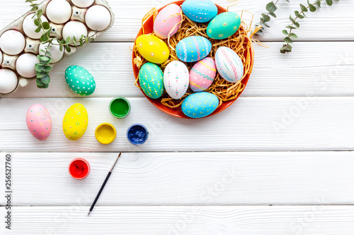 eggs with colorful paint for easter tradition on white wooden background top view mockup