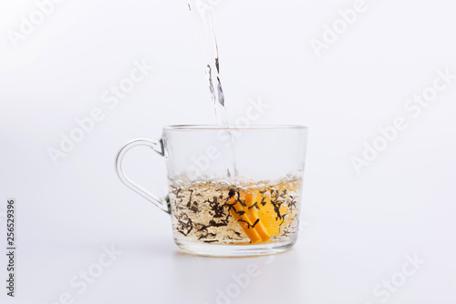 Black tea pouring into glass cup Isolated on white background