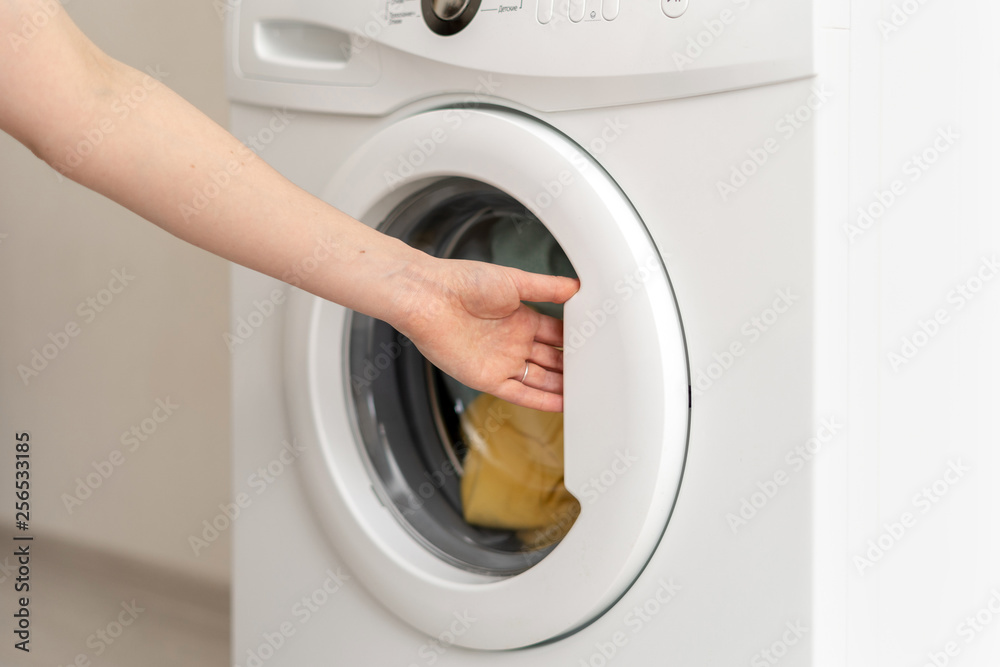 Laundry room interior with washing machine near wall Laundry room interior with washing machine near wall