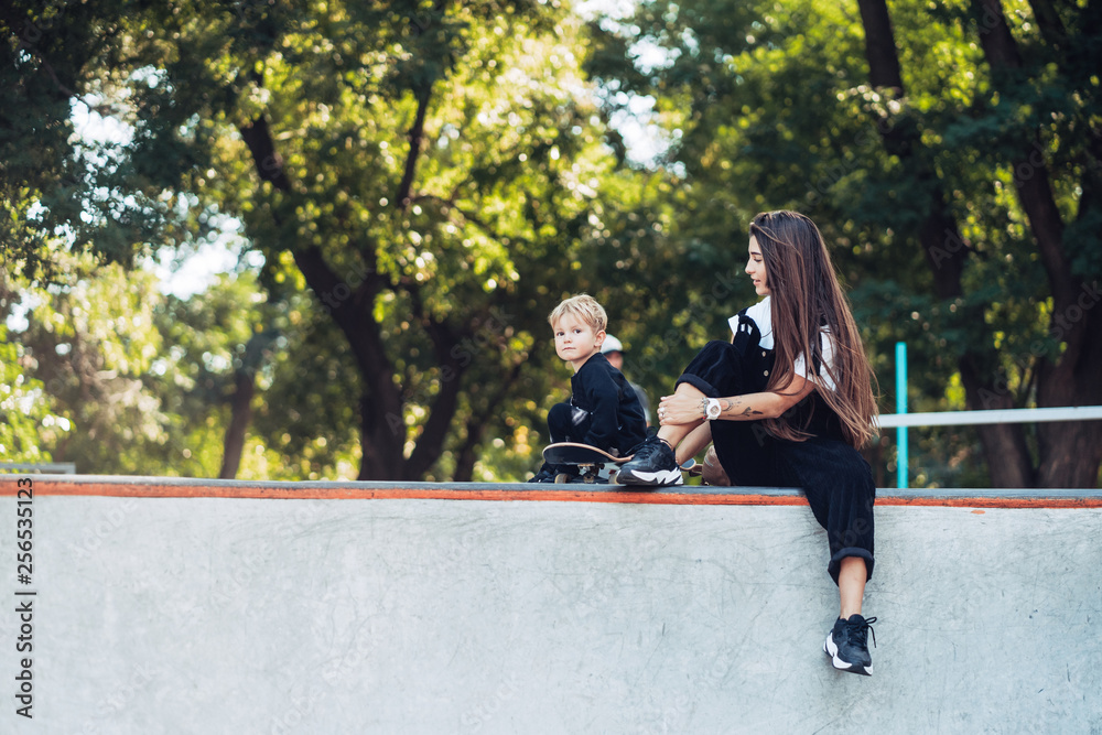 Beautiful young hipster mom and little son at the skatepark Beautiful young hipster mom and little son at the skatepark