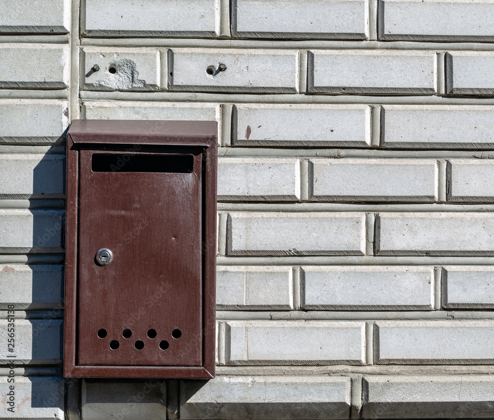 old mail box hanging on the white brick wall old mail box hanging on the white brick wall