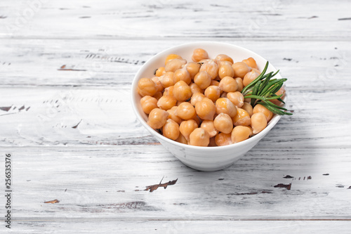 Cooked chickpeas in white bowl with spice of rosemary photo