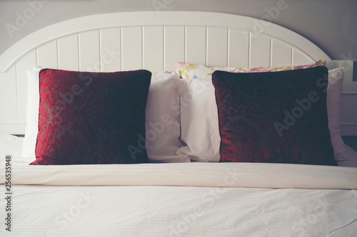 Red pillow on a white bed