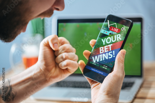 Tablou pe pânză Man celebrating victory after making bets at bookmaker website