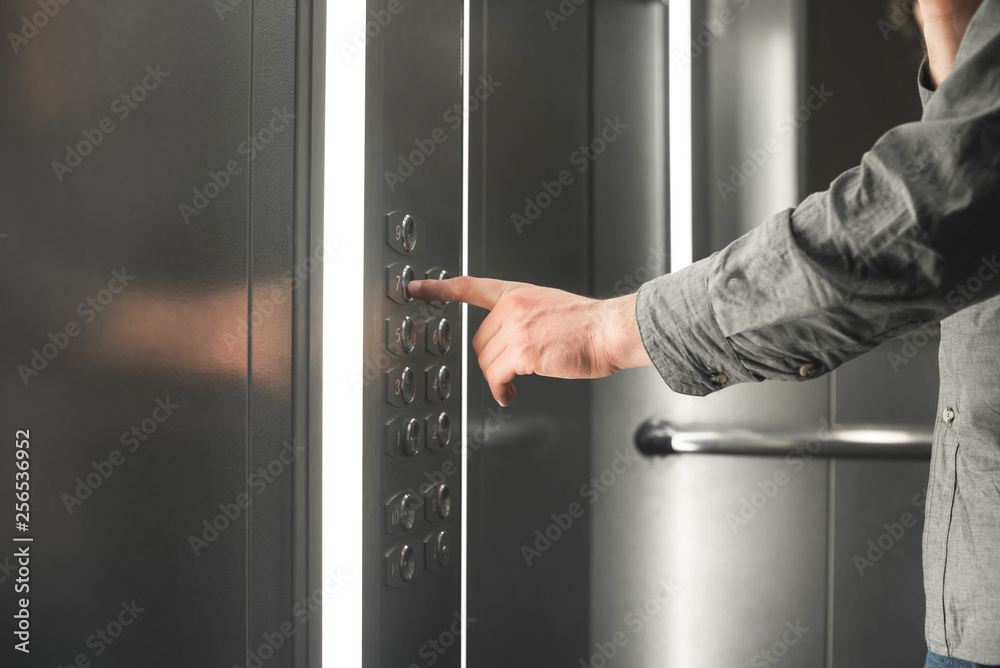 Man's hand presses the lift button. Close-up photo of a hand chooses a floor in the elevator. Man's hand presses the lift button. Close-up photo of a hand chooses a floor in the elevator.