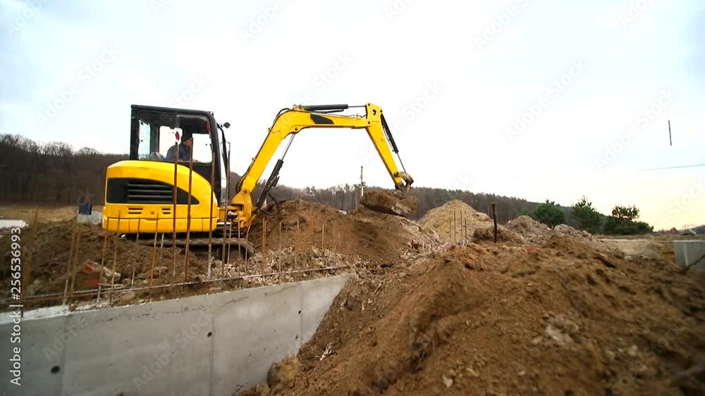 Slow motion of a digger digging a pit and throwing dirt. Close-up of a excavator bucket that throws out the earth. Shot by wide angle lens Slow motion of a digger digging a pit and throwing dirt. Close-up of a excavator bucket that throws out the earth. Shot by wide angle lens