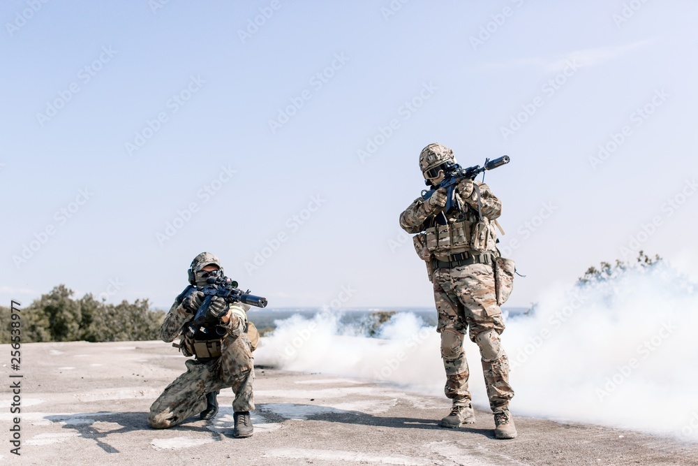 Military with sniper rifles preparing to fire on the enemy standing in the open air Military with sniper rifles preparing to fire on the enemy standing in the open air