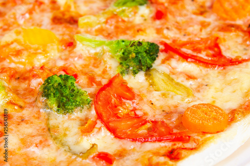 Delicious pizza with broccoli, tomatoes and vegetables, closeup shot