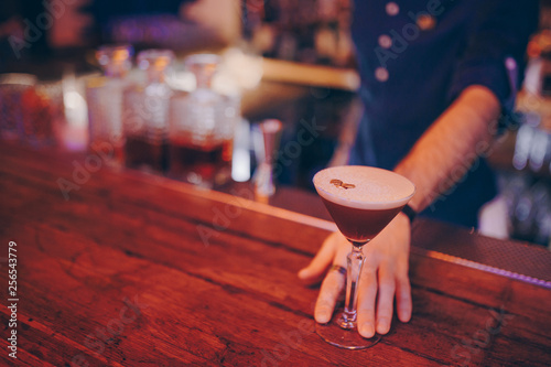 Bartender hand holding tasty coffee alcoholic old fashioned with golden beans  . Copy paste space for design people and luxury concept service barman in nightclub