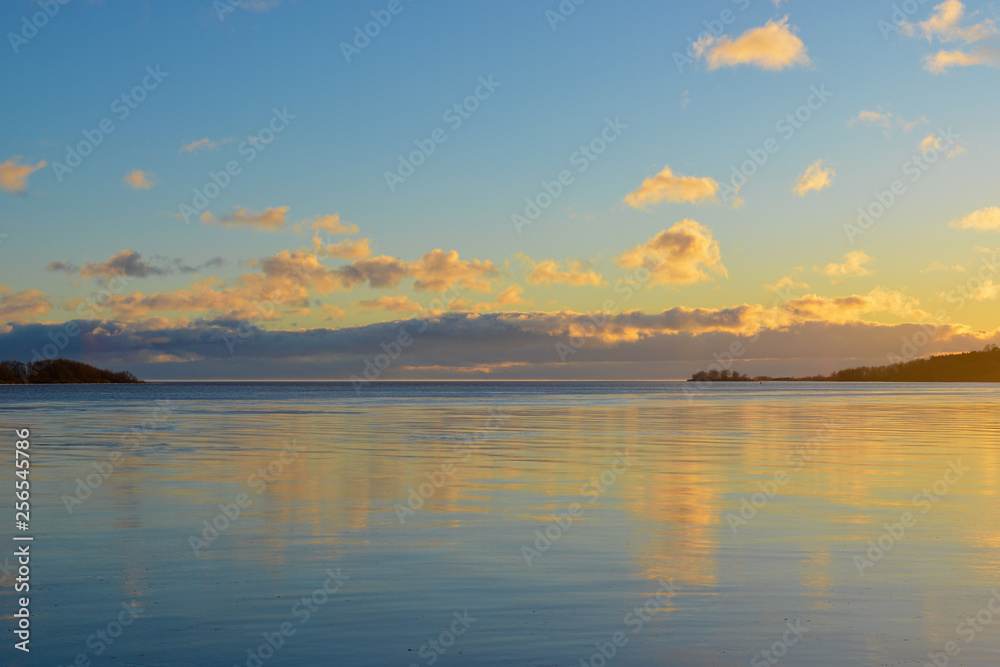 Fototapeta premium Winter landscape with lake and sunset clouds