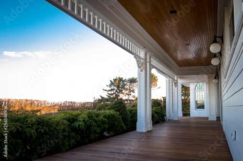 Pillars, millwork, and front window overlooking patio and deck of house with a view of blue skies