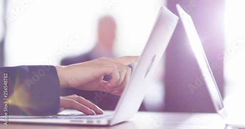 4K Senior businessman in bright sunlit office with worker using laptop in foreground. Slow motion.