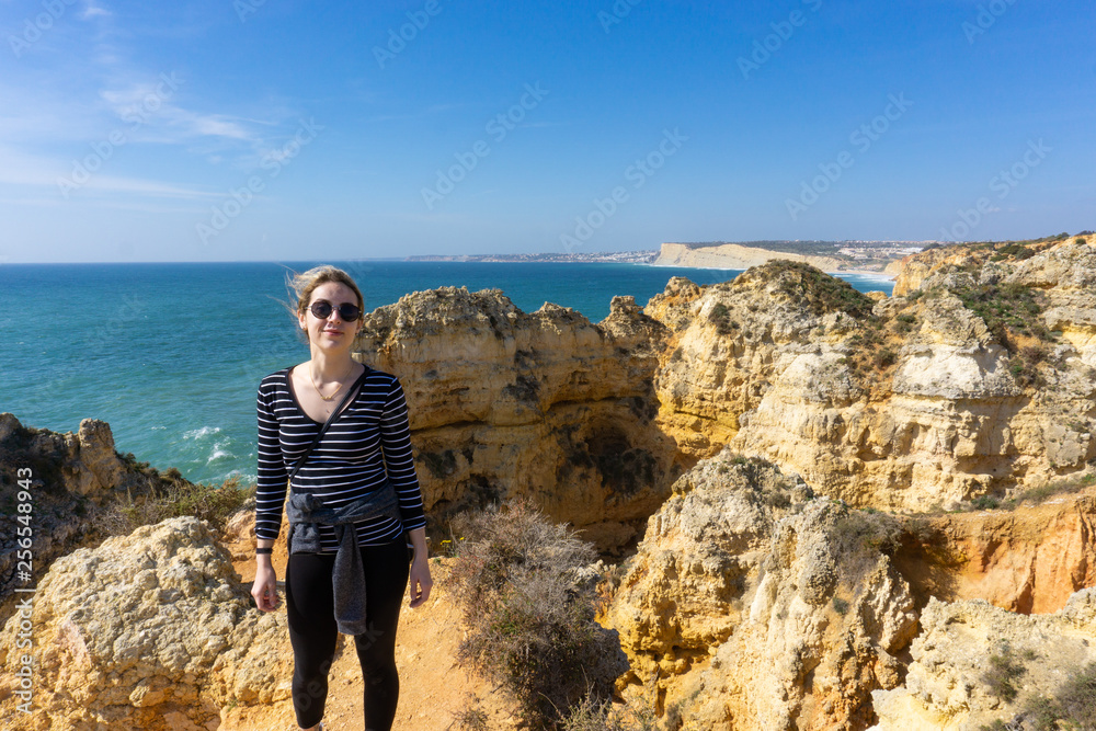 Beautiful young woman poses in front of ocean scene