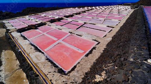 24 November 2018 La Palma Canary Islands, Salinas Marinas de Fuencaliente, Salts Flats and Mine showing multi coloured salt water fields aganst blue sky and waves photo